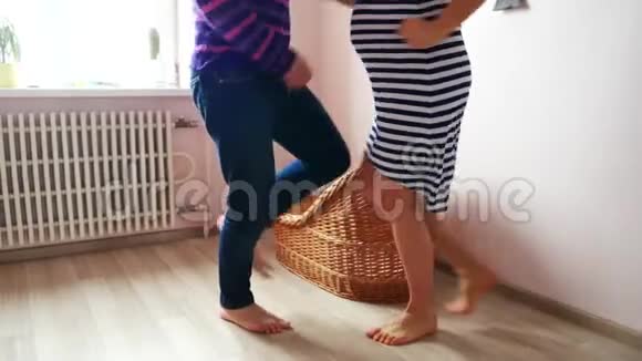 一个男人和一个孕妇正在婴儿床附近跳舞等待怀孕家庭视频的预览图