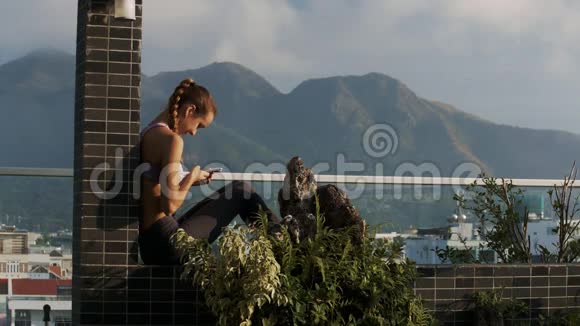 女孩在露台上看手机短信视频的预览图