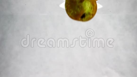 绿梨掉进水里有很多小气泡孤立的白色背景上的水果视频视频的预览图