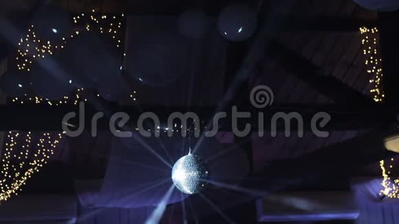 光线从迪斯科球反射照亮烟雾迪斯科球旋转无缝片黑色视频的预览图