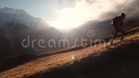 一个女孩在山的边缘行走作为一个美丽的剪影这是一个很长的航拍镜头视频的预览图