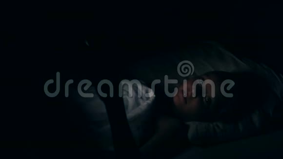 一个女孩躺在床上看着电话里的恐怖晚上看电影那个白人女孩晚上不睡觉这就是视频的预览图