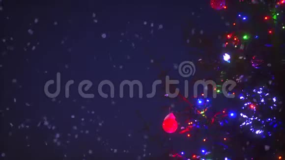 圣诞树的特写树枝五颜六色的花环被雪花动画包围视频的预览图