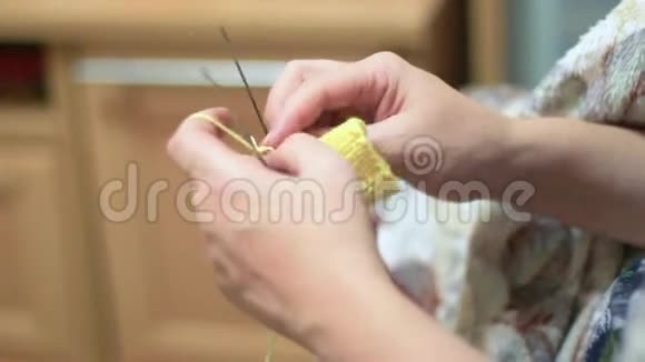 人们和家庭观念女人用钩子和黄纱编织视频的预览图