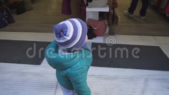 一岁的男孩正在考虑开一家商店这孩子仔细检查了商店的内部慢动作视频的预览图
