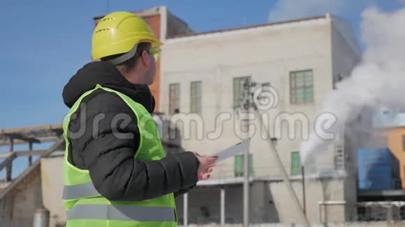 戴安全帽的工程师正在一家工业工厂使用平板电脑视频的预览图