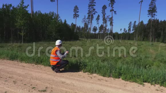 森林管理员在森林道路上降落无人机视频的预览图