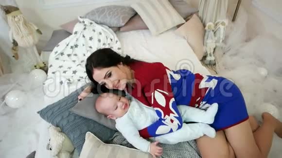 母亲和婴儿的肖像年轻的女人抚摸拥抱抚摸他的小儿子家庭在一个舒适的家视频的预览图