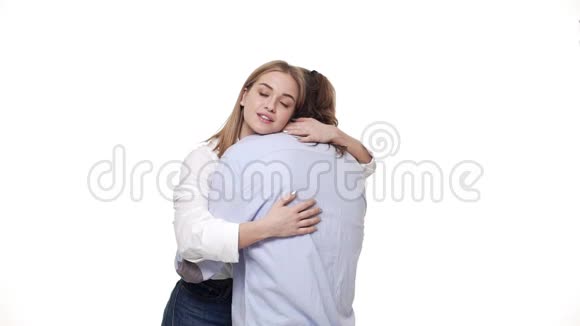 年轻的女朋友高兴地拥抱她的男朋友在白色工作室背景视频的预览图