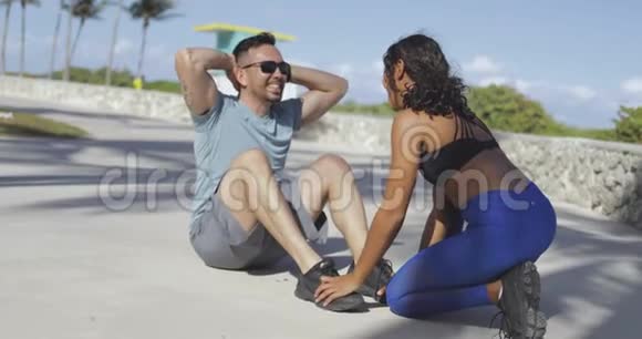 女孩帮助男人进行腹肌锻炼视频的预览图
