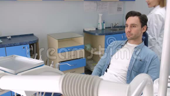 女牙医在诊所问候男性病人视频的预览图