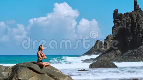 瑟琳冥想瑜伽布鲁内特旅游妇女在风景优美的普拉亚达马林哈上的海角上沉思视频的预览图