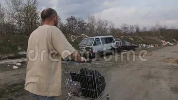 垃圾填埋场男性推购物车后视图视频的预览图