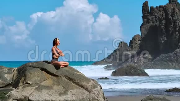 瑟琳冥想瑜伽布鲁内特旅游妇女在风景优美的普拉亚达马林哈上的海角上沉思视频的预览图