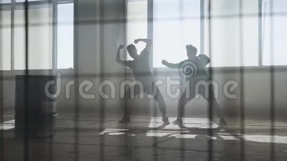 两个人在废弃建筑的大窗户前跳舞同时跳舞的青少年视频的预览图