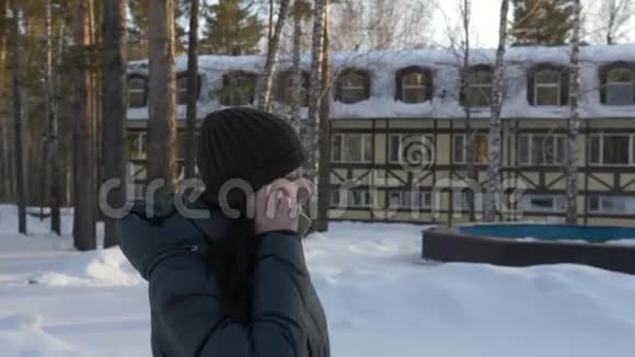 肖像成年妇女在冬天散步时用手机说话视频的预览图