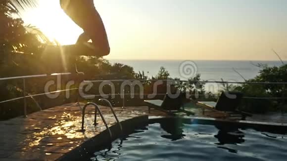 有动作的年轻人在日落时在游泳池的水中跳过太阳慢动作1920x1080视频的预览图