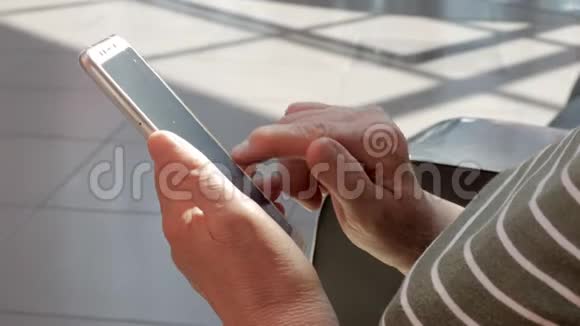 使用现代智能手机的老年妇女的手视频的预览图
