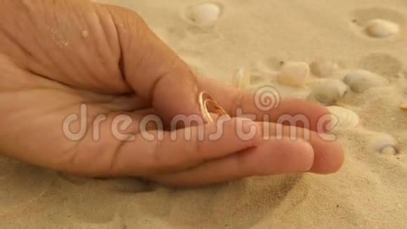 海沙中的金婚戒指视频的预览图