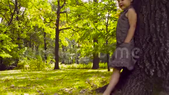 一个女孩站在公园的树旁吃披萨视频的预览图