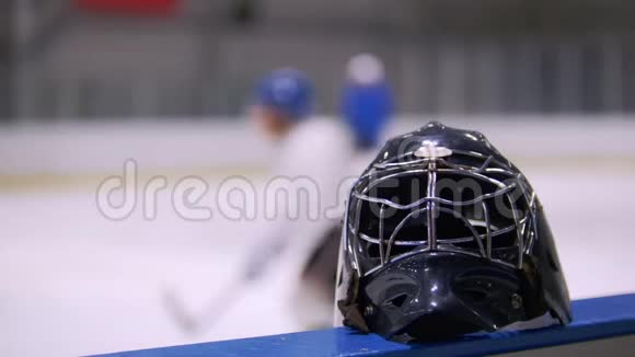 曲棍球头盔靠近曲棍球运动员在曲棍球场上比赛的背景视频的预览图