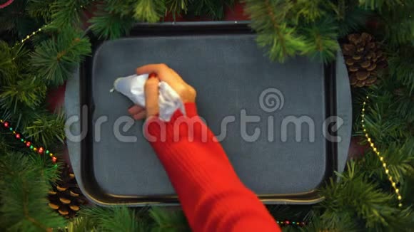 圣诞节女人在烤盘上用奶油写字庆祝节日视频的预览图