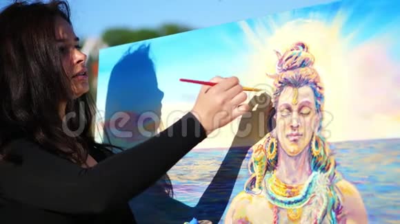 夏天在户外靠近河边一位美丽的女艺术家正在画画用一种特殊的小画布涂上油漆视频的预览图