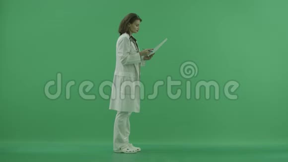 医生向右看检查绿色屏幕上的文件视频的预览图