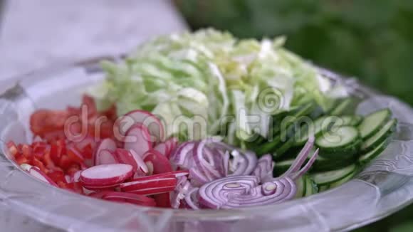 新鲜切碎的夏沙拉许多美味的蔬菜在玻璃沙拉碗黄瓜生菜萝卜西红柿红葱视频的预览图