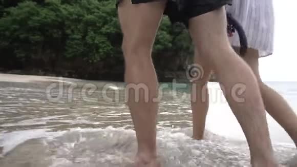 在海边散步的情侣腿特写后视男子和妇女视频的预览图