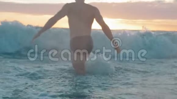 日落时肌肉发达的人在海洋中缓慢地游泳视频的预览图