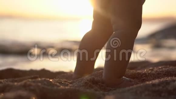 惊人的腿的婴儿使台阶在沙滩上日落视频的预览图