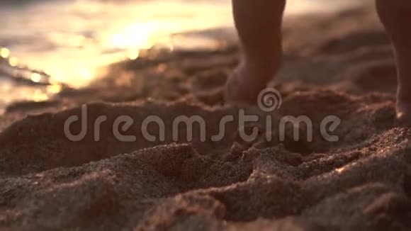 可爱的特写镜头的婴儿腿使台阶在沙滩上视频的预览图