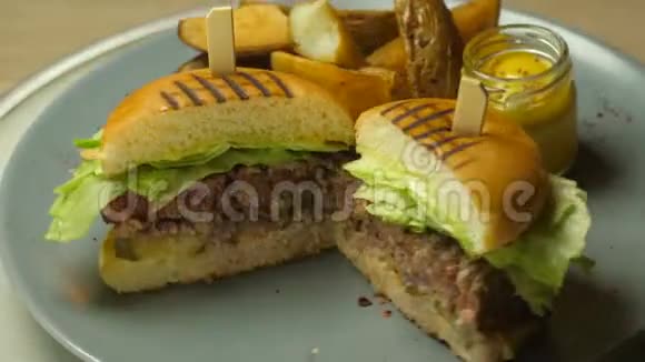 汉堡包是美味多汁的有牛肉或羊排奶酪腌制黄瓜生菜和烤土豆视频的预览图