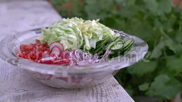 新鲜切碎的夏沙拉许多美味的蔬菜在玻璃沙拉碗黄瓜生菜萝卜西红柿红葱视频的预览图