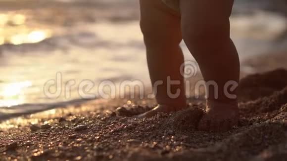 惊人的腿的婴儿使台阶在沙滩上日落视频的预览图