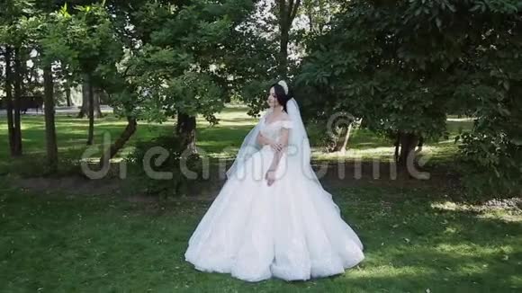 一位非常漂亮的新娘独自站在公园里一边焦急地等待着新郎视频的预览图