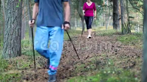 在森林小径上的一对老夫妇带着步行杆视频的预览图
