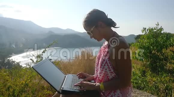 女商人用手提电脑完成工作在岩石上放松慢动作1920x1080视频的预览图