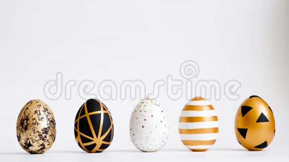 鸡蛋在白色的桌子上滚动互相敲门复活节金色装饰的彩蛋在白色背景上分离最小复活节co视频的预览图