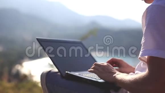 商人坐在岩石上用笔记本电脑工作1920x1080视频的预览图