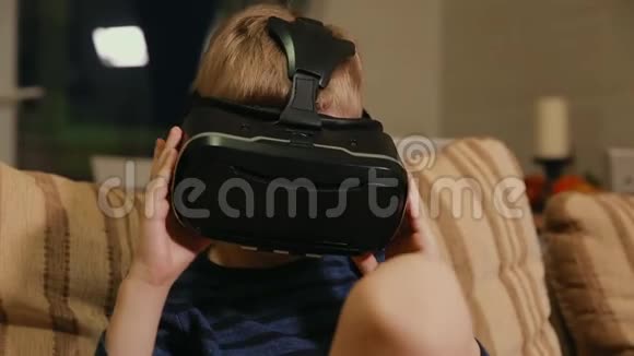 男孩67年在家玩借助虚拟现实护目镜的电子游戏特写视频的预览图