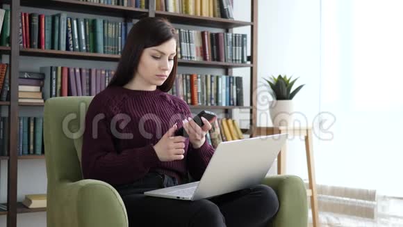 使用智能手机和笔记本电脑上班的休闲静坐妇女视频的预览图