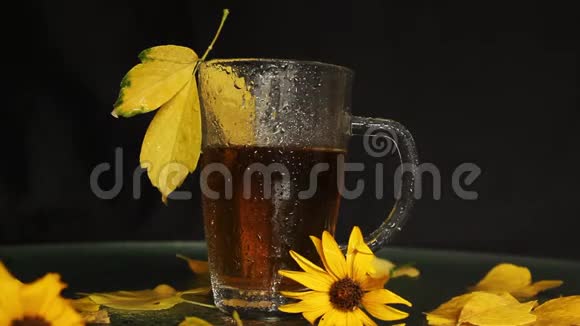 秋天的景色中一阵热茶雨后一个透明的杯子湿了黄黄的落叶黄花视频的预览图