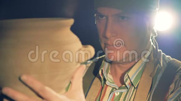 一个陶工在手中拧碗时面对视频的预览图