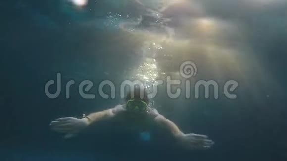 年轻人在水下透过阳光游泳动作缓慢1920x1080视频的预览图