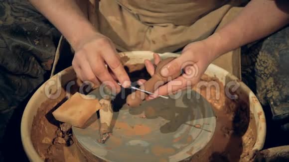 陶工在绿色器皿手柄上使用清洁工具视频的预览图