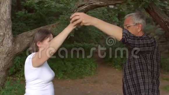 快乐的老人和女人在森林公园跳舞视频的预览图