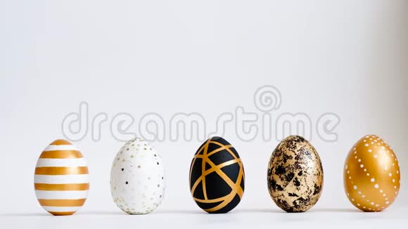 鸡蛋在白色的桌子上滚动互相敲门复活节金色装饰的彩蛋在白色背景上分离最小复活节co视频的预览图