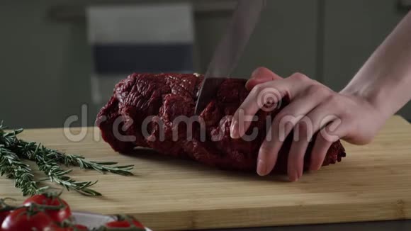 火腿切割片的特写场景女人手切成两块多汁的火腿把火腿切在木头上视频的预览图